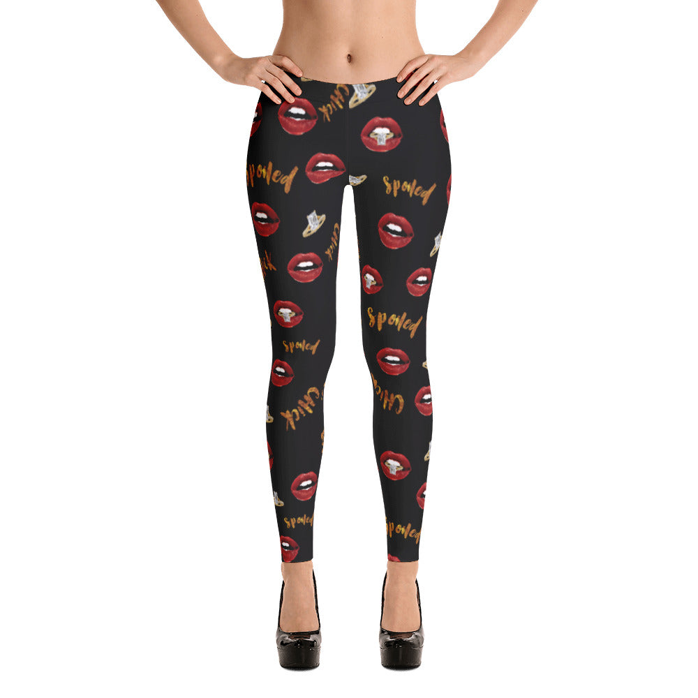 A pair of black leggings with a pattern of lips and the text 'Spoiled Chick' printed on them.